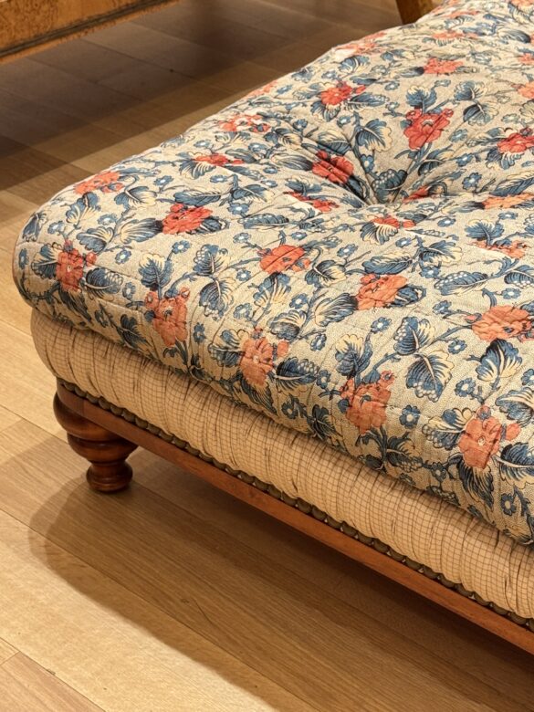 A close-up of an ornate vintage chair with an abstract painting in the background