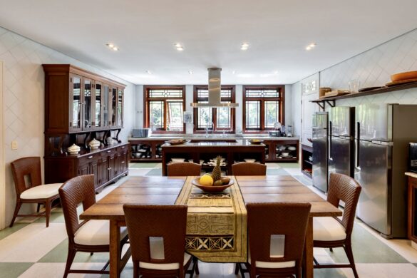 A Hand made locally in braziloain Ipe kitchen featuring colonial-style cabinetry, geometric floor tiles, and large windows filtering natural light